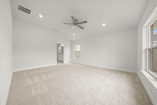 unfurnished room with ceiling fan, vaulted ceiling, and light carpet