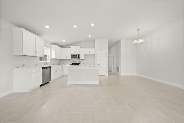 kitchen featuring white cabinetry, lofted ceiling, a chandelier, a center island, and stainless steel appliances