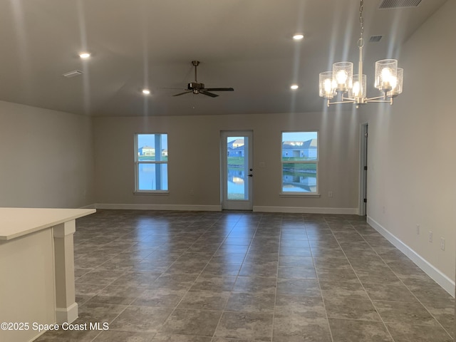 unfurnished living room with ceiling fan with notable chandelier