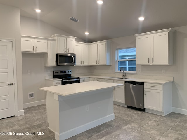 kitchen featuring lofted ceiling, appliances with stainless steel finishes, sink, and white cabinets