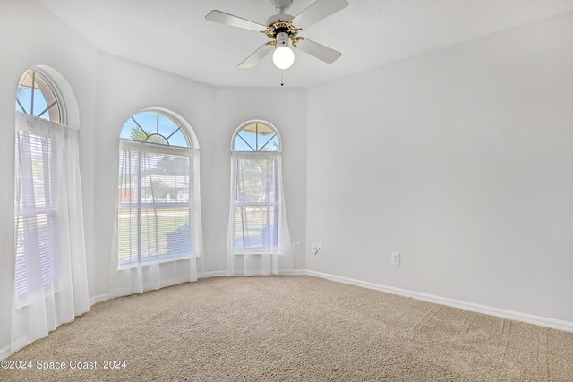 unfurnished room featuring ceiling fan and light carpet