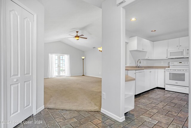 kitchen featuring dark carpet, white appliances, lofted ceiling, ceiling fan, and white cabinets