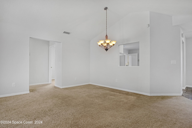 carpeted empty room featuring high vaulted ceiling and a notable chandelier