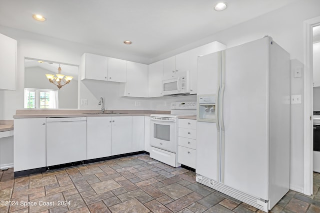 kitchen with white appliances, pendant lighting, sink, a chandelier, and white cabinetry