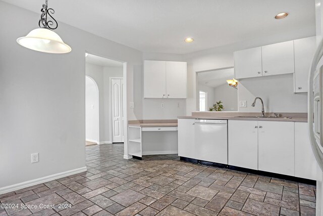 kitchen with white dishwasher, sink, and white cabinets