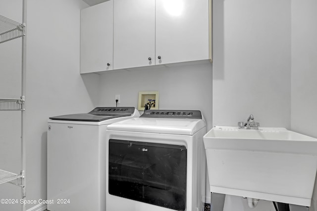 laundry room featuring cabinets, independent washer and dryer, and sink