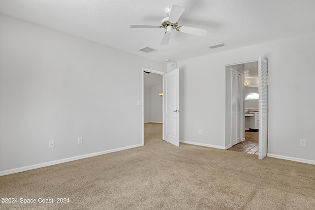 unfurnished bedroom with ceiling fan and light colored carpet