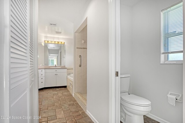 bathroom with an enclosed shower, toilet, plenty of natural light, and vanity