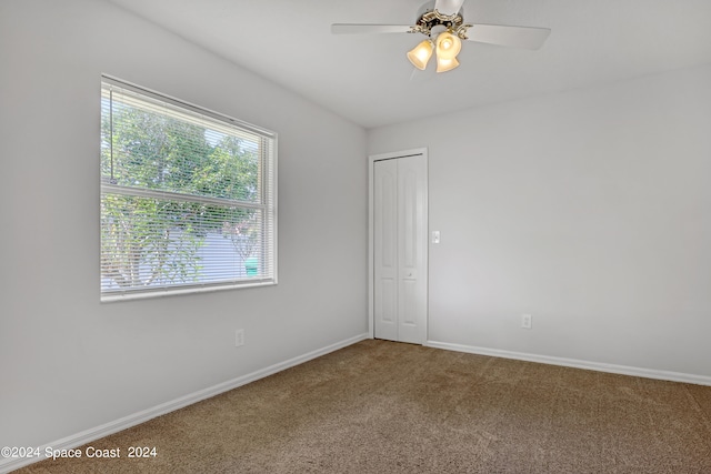 carpeted empty room with plenty of natural light and ceiling fan