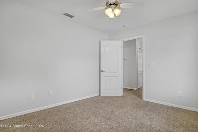 spare room featuring ceiling fan and carpet flooring