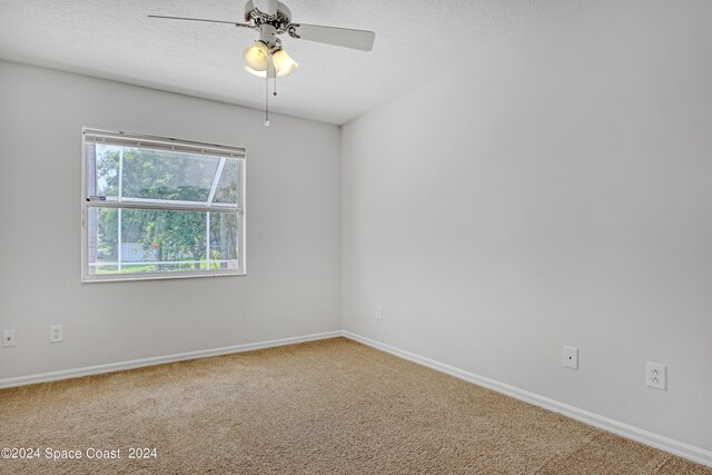 unfurnished room with a textured ceiling, ceiling fan, and carpet