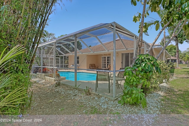 view of pool with a patio area and glass enclosure