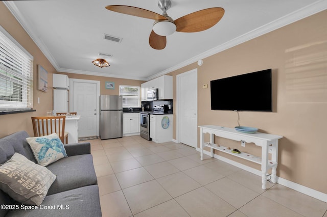 living room featuring light tile patterned floors, visible vents, baseboards, a ceiling fan, and ornamental molding