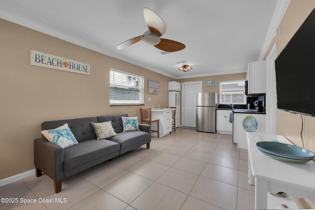 living area featuring a healthy amount of sunlight, a ceiling fan, and crown molding