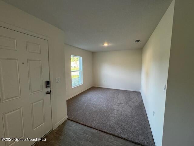 carpeted foyer with visible vents and baseboards