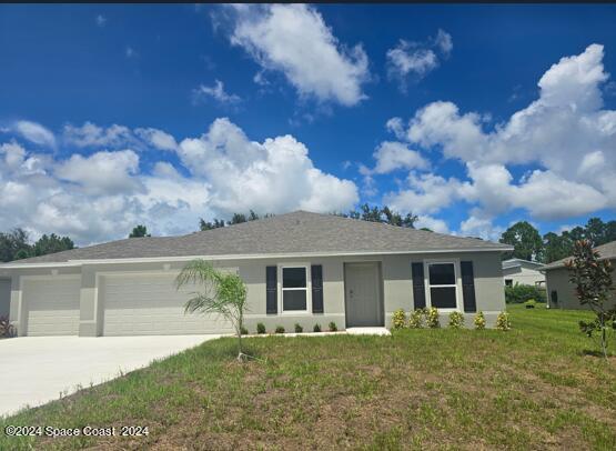 single story home featuring a garage, a front yard, concrete driveway, and stucco siding