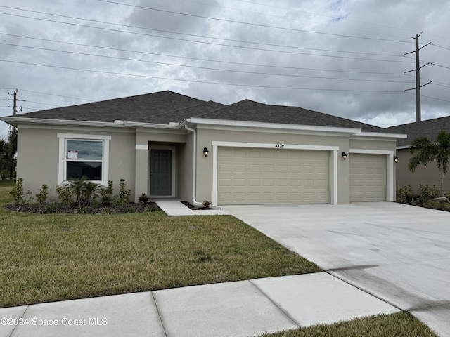 view of front of home featuring a front yard and a garage