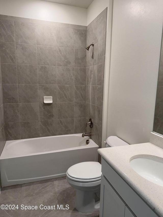 full bathroom featuring toilet, vanity, and tiled shower / bath