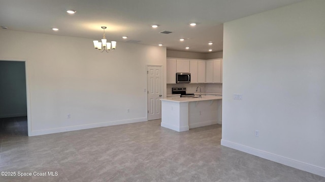 4376 Kelsey Ln, Sebastian, FL 32976 - kitchen featuring appliances with stainless steel finishes, a chandelier, light countertops, white cabinetry, and recessed lighting