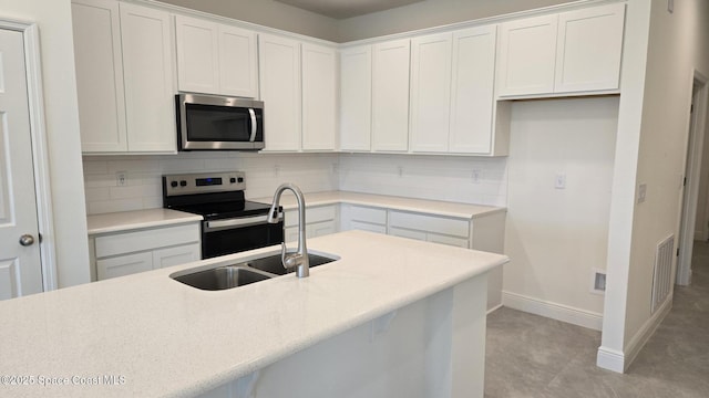 4376 Kelsey Ln, Sebastian, FL 32976 - kitchen with stainless steel appliances, backsplash, and white cabinets