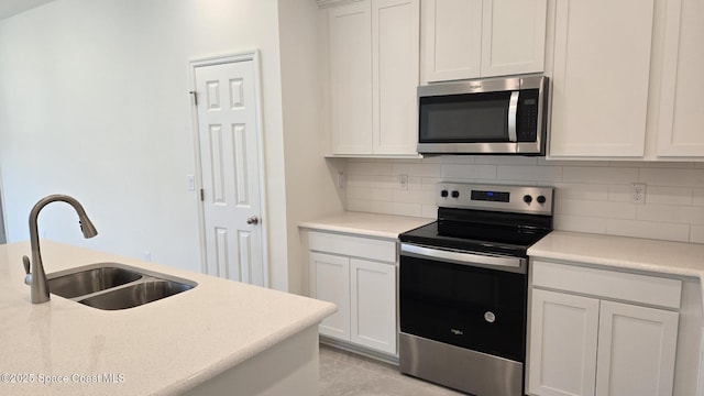 4376 Kelsey Ln, Sebastian, FL 32976 - kitchen featuring appliances with stainless steel finishes, tasteful backsplash, light countertops, and white cabinets