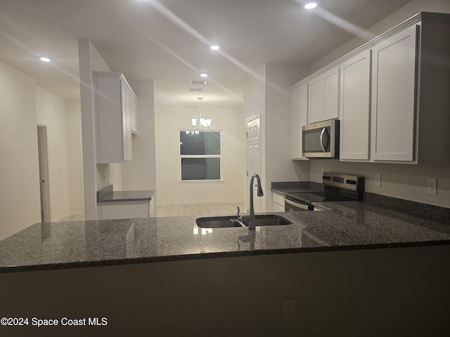 kitchen with white cabinets, kitchen peninsula, sink, and appliances with stainless steel finishes