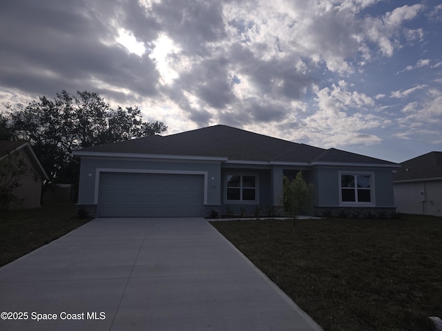 ranch-style home with a garage and a front lawn