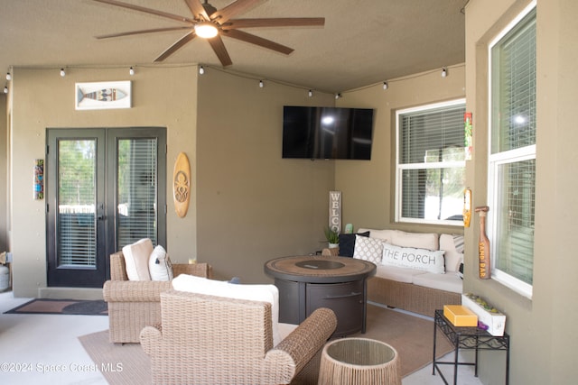 view of patio / terrace with an outdoor living space with a fire pit and ceiling fan