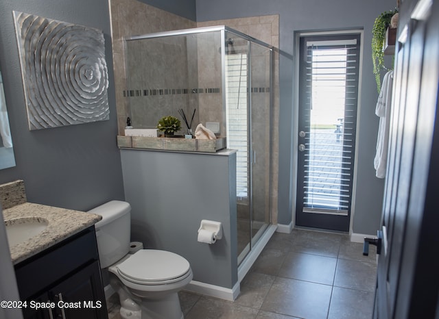 bathroom featuring tile patterned flooring, vanity, an enclosed shower, and toilet