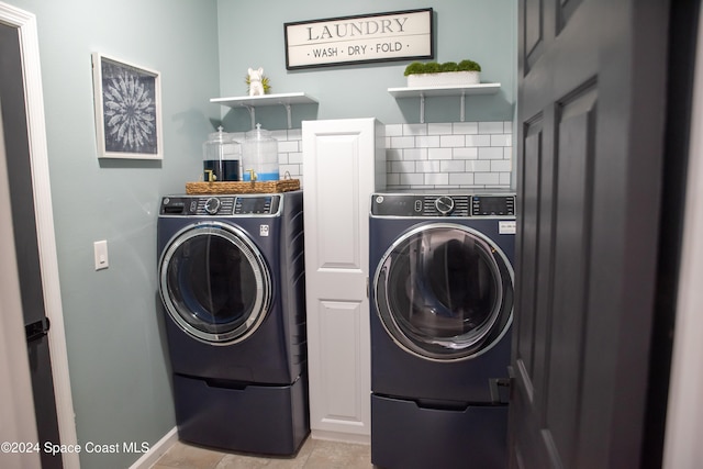 laundry room with washing machine and dryer, cabinets, and light tile patterned flooring