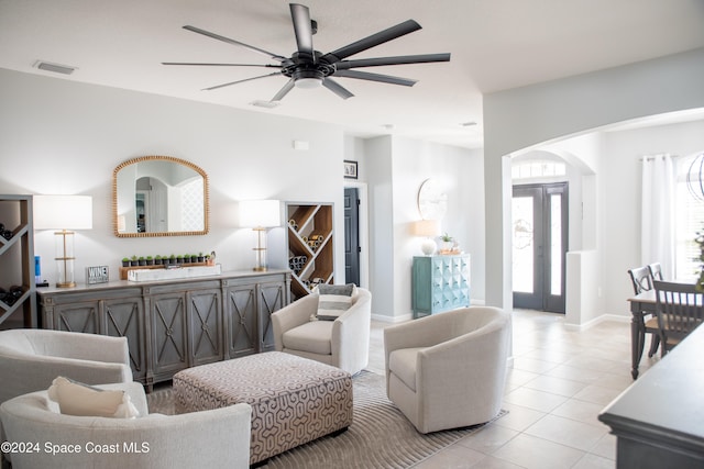 living room featuring light tile patterned floors, ceiling fan, and french doors