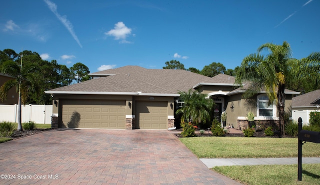 680 Easton Forest Cir SE, Palm Bay, FL 32909 - view of front of home with stucco siding, an attached garage, decorative driveway, and stone siding