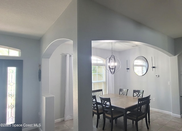 680 Easton Forest Cir SE, Palm Bay, FL 32909 - dining area featuring light tile patterned floors, a chandelier, baseboards, and arched walkways