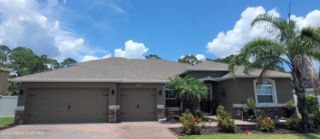 680 Easton Forest Cir SE, Palm Bay, FL 32909 - view of front of home featuring stucco siding, decorative driveway, a garage, a shingled roof, and stone siding
