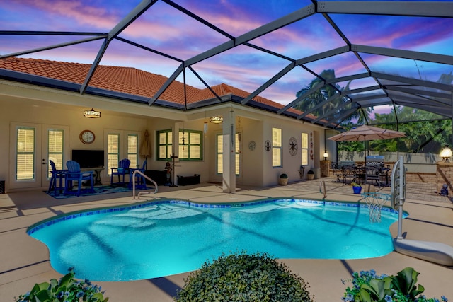 view of swimming pool featuring a lanai, ceiling fan, french doors, and a patio area