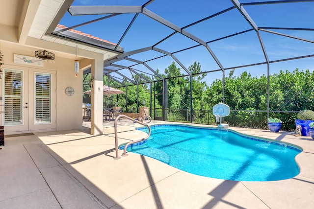 view of pool with glass enclosure and a patio area