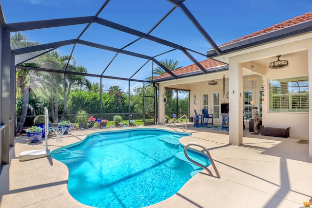 view of swimming pool with a patio, glass enclosure, and ceiling fan