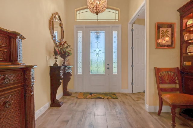 entryway featuring light hardwood / wood-style flooring, plenty of natural light, and a chandelier