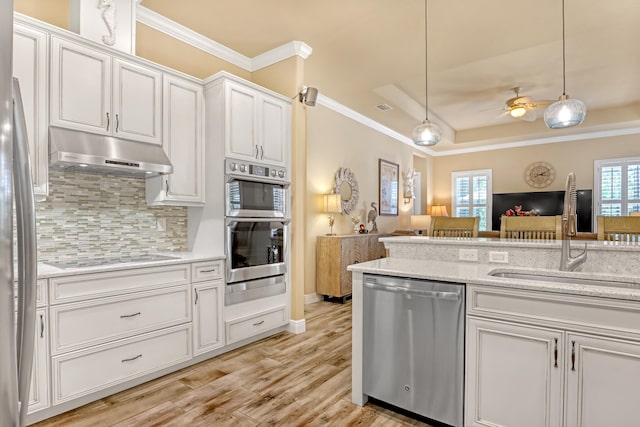 kitchen with pendant lighting, white cabinets, light hardwood / wood-style flooring, appliances with stainless steel finishes, and ceiling fan