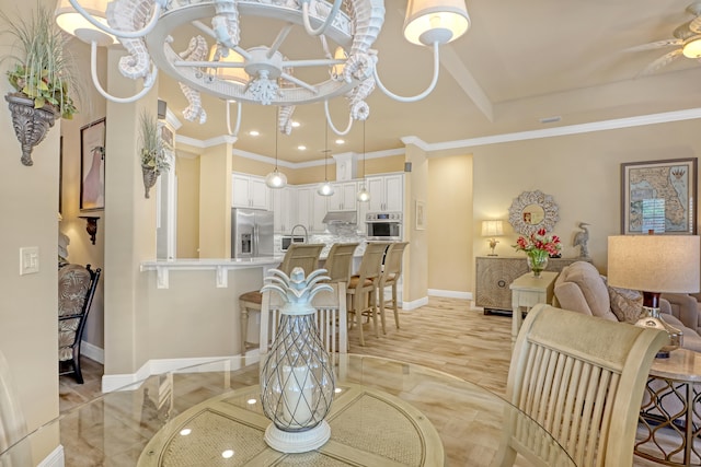 living room featuring ceiling fan with notable chandelier, ornamental molding, and sink