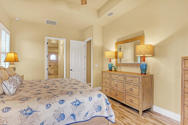 bedroom with light hardwood / wood-style floors, ensuite bathroom, and ceiling fan