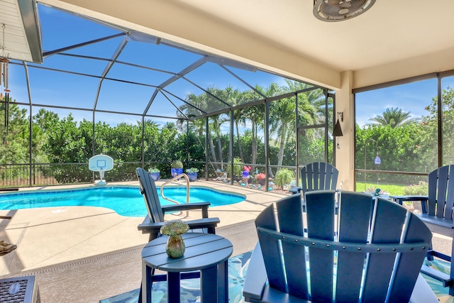 view of swimming pool with glass enclosure and a patio area