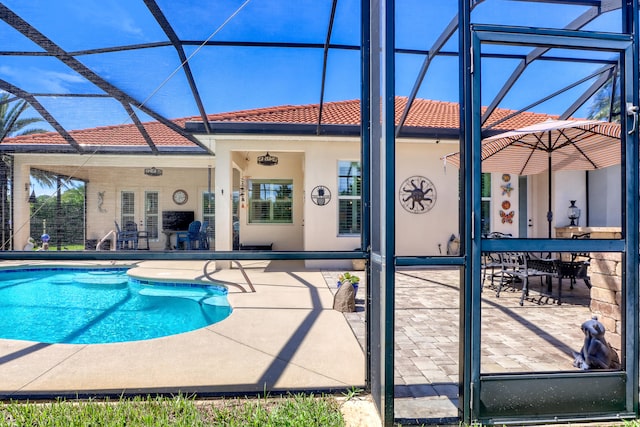 view of pool with ceiling fan, a lanai, and a patio area