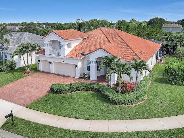 mediterranean / spanish-style home featuring a balcony, a front yard, and a garage