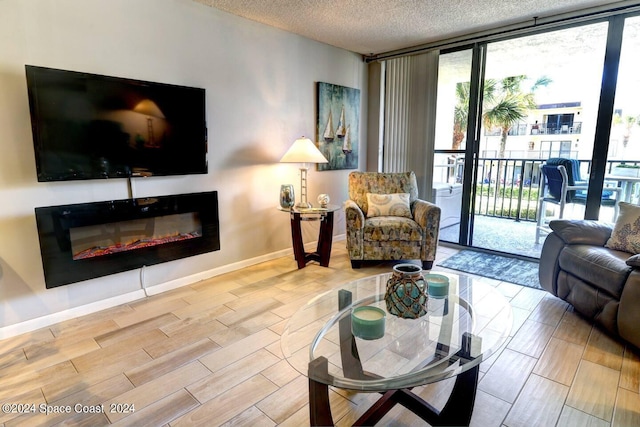 living room featuring a textured ceiling and floor to ceiling windows