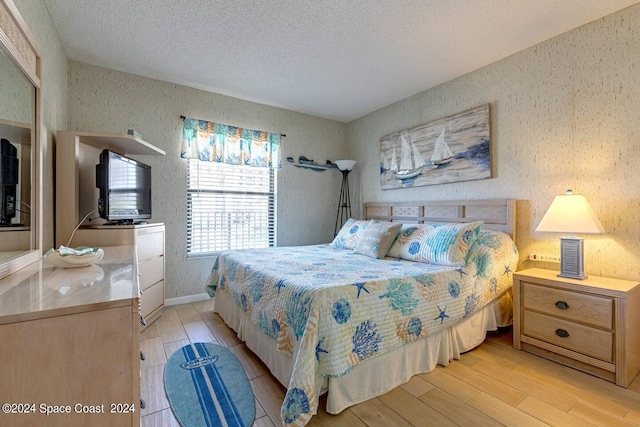 bedroom featuring a textured ceiling and light hardwood / wood-style floors