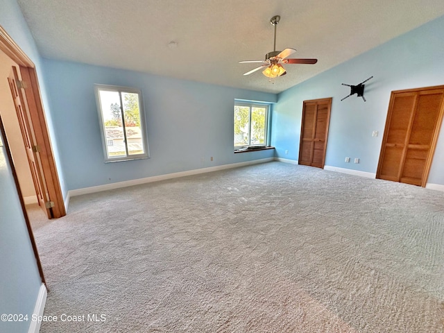 1248 Water Lily Ln, Rockledge, FL 32955 - unfurnished bedroom with vaulted ceiling, carpet floors, ceiling fan, multiple closets, and a textured ceiling