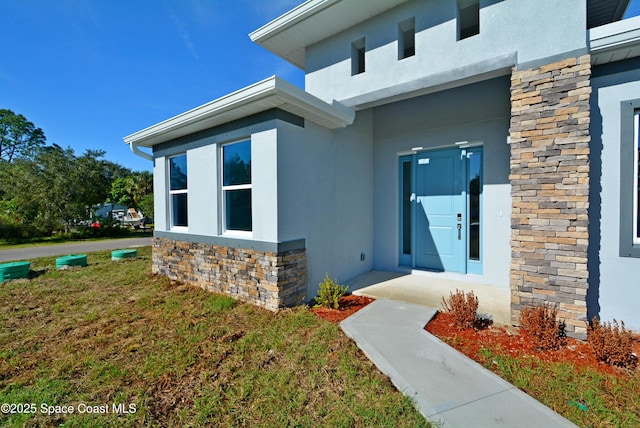 entrance to property with a lawn