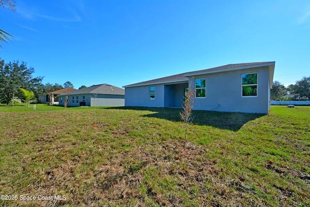 rear view of property with a lawn