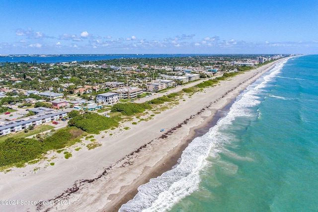 drone / aerial view featuring a beach view and a water view